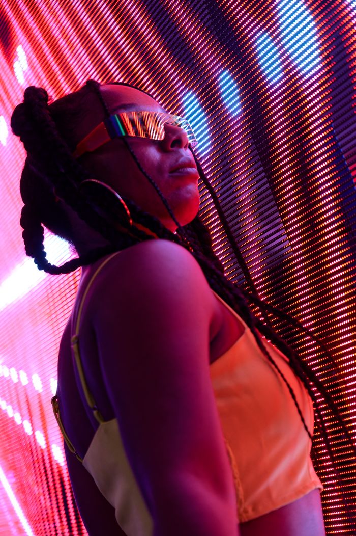 gallery-6 Stylish woman in neon ambiance, showcasing modern fashion and nightlife vibes.